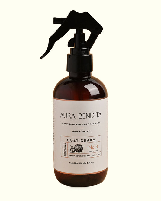 Cozy Charm, aromatizante de ambiente de 250 ml de Aura Bendita: frasco sobre fondo marfil